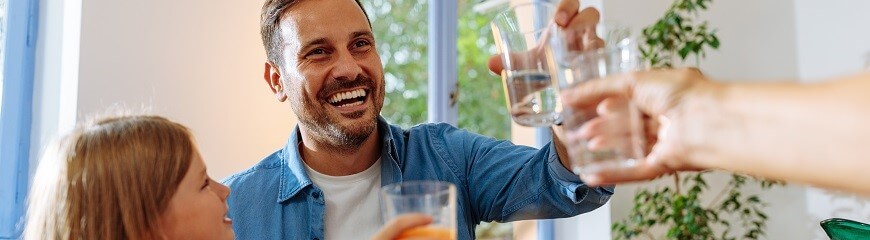 Family doing cheers with glasses of water