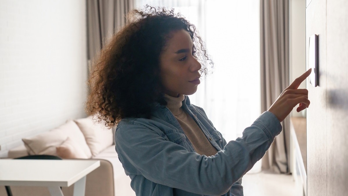 Woman checking home thermostat